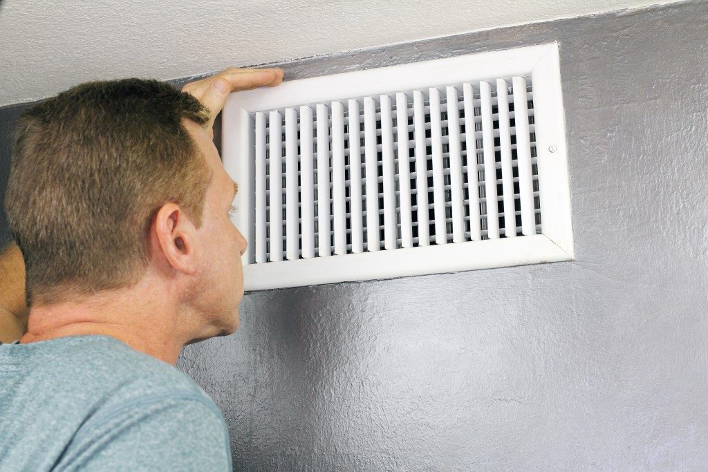Man checking air vent