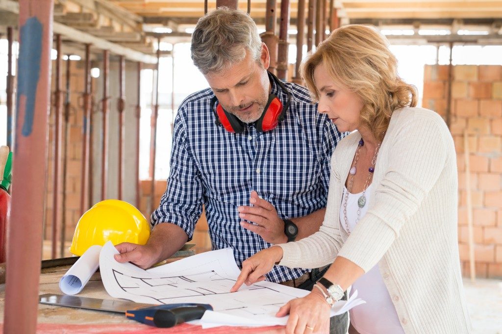 Architect and woman discussing floor plan