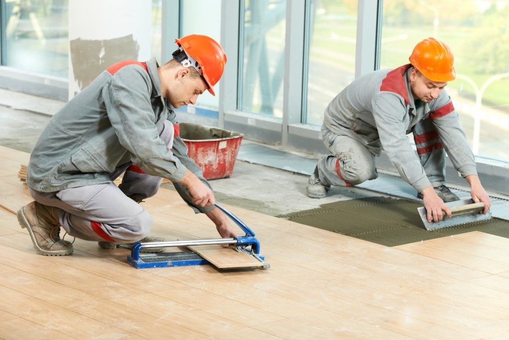 Workers installing tiles in a house