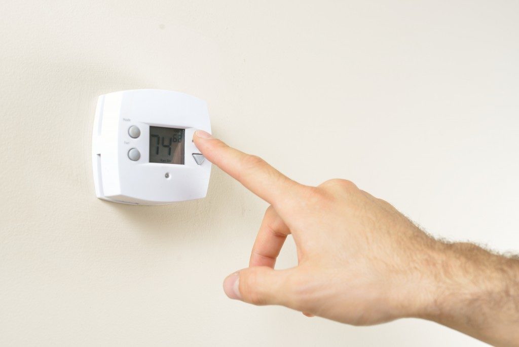 Man adjusting floor heating thermostat