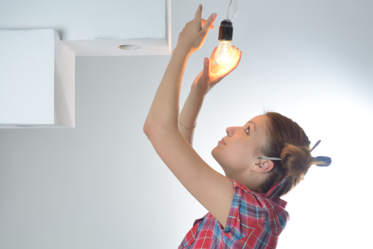 Woman changing light bulb