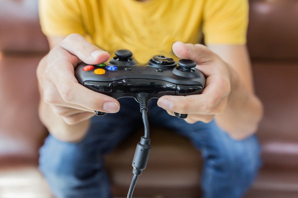 Young man holding game controller playing video games