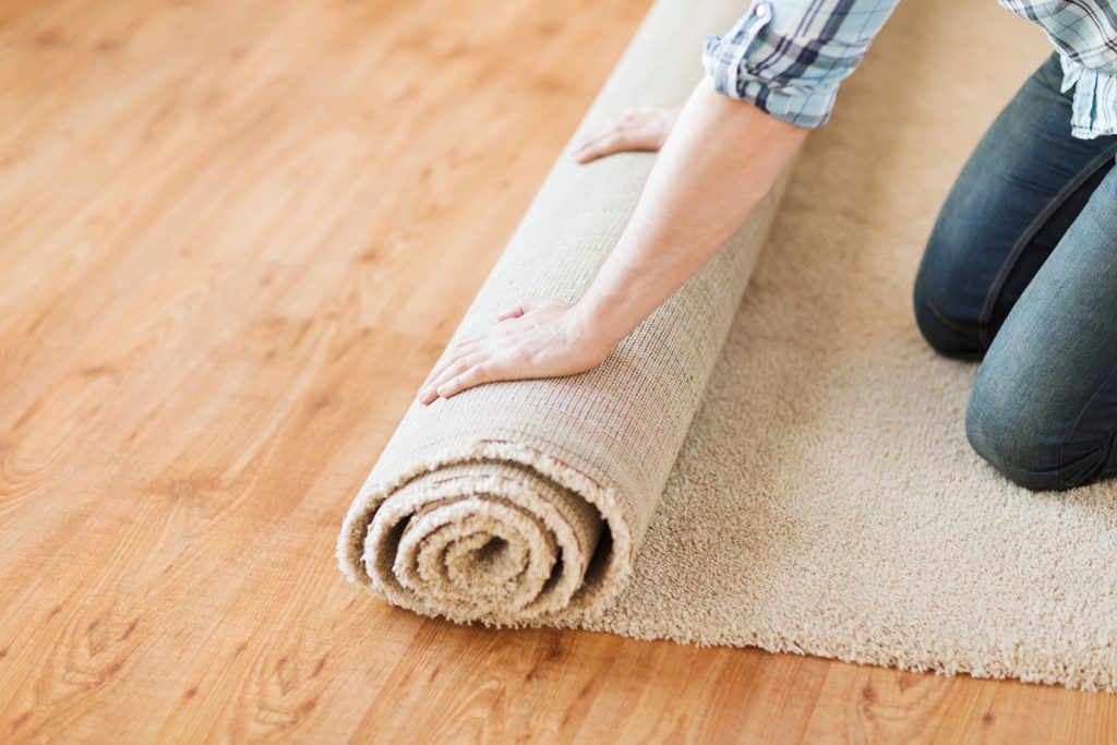 Flooring Materials -Person rolling a carpet on the floor