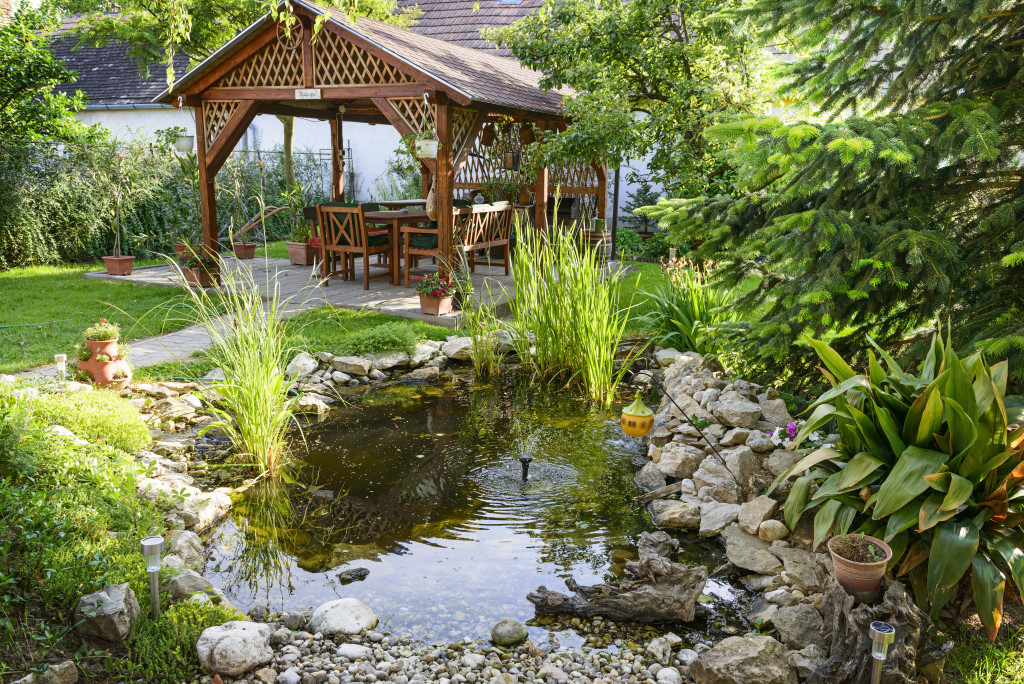 Backyard with a little pond and covered living area to relax.